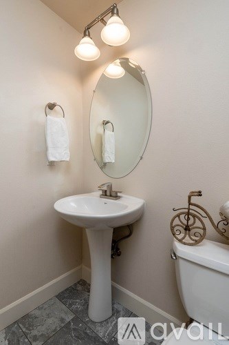 A bathroom with a sink, mirror, and towel rack.