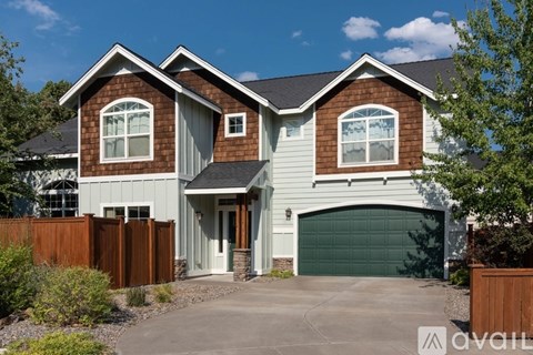 A house with a brown and white exterior and a garage door.