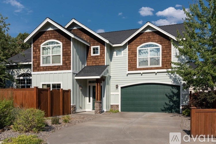 A house with a brown and white exterior and a garage door.