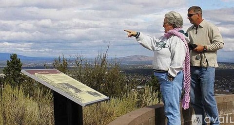 A woman points to a sign while standing with a man.