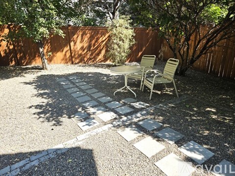 A backyard with a table and chairs.