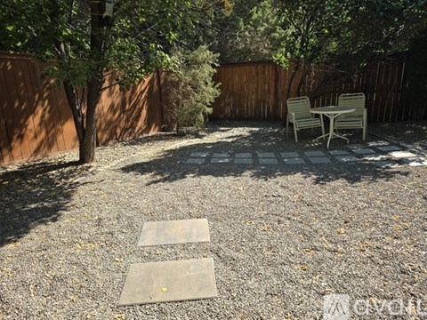 A backyard with a table and chairs.