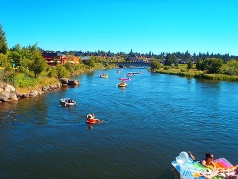 People are kayaking and floating on the river.