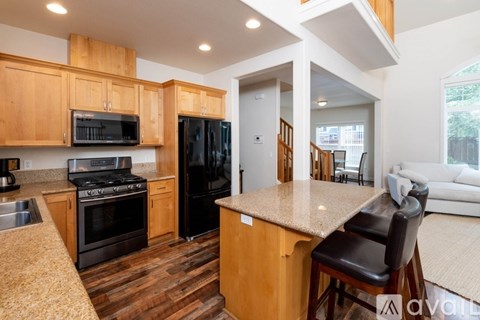 A kitchen with wooden cabinets and black appliances.