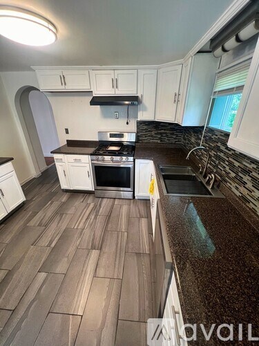 A kitchen with white cabinets and a brown countertop.