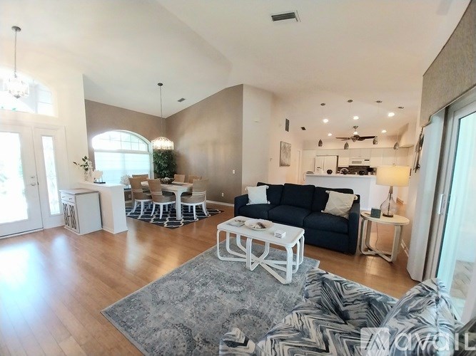 A living room with a black couch and a white coffee table.