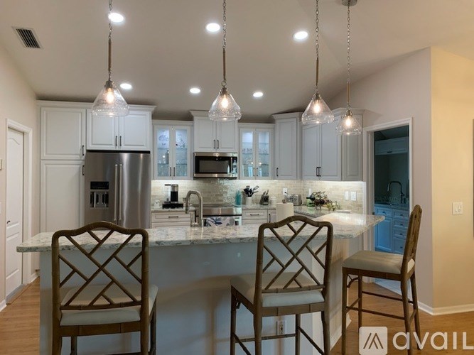 A modern kitchen with a center island and pendant lights.