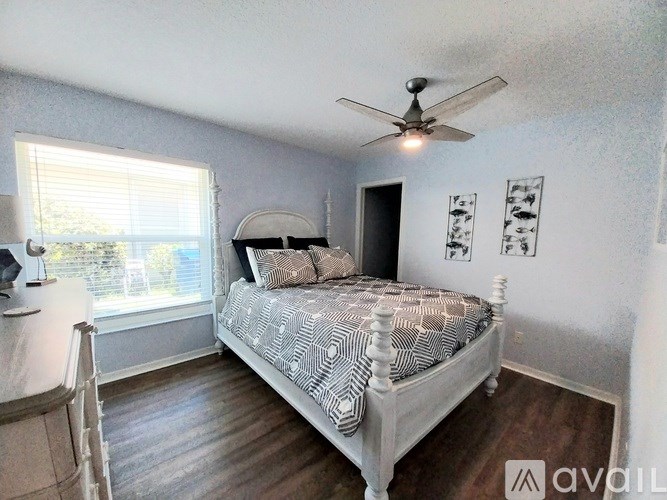 A bedroom with a bed, dresser, and window.