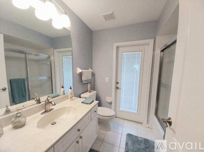 A bathroom with a sink, mirror, toilet and shower.