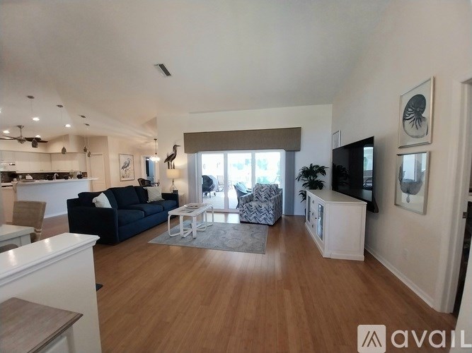 A living room with a black couch and a television.