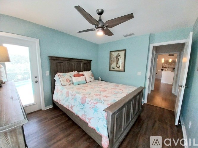 A bedroom with a bed, dresser, and a ceiling fan.