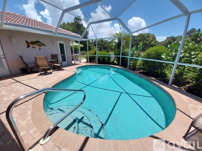 A small pool in a backyard with a glass enclosure.