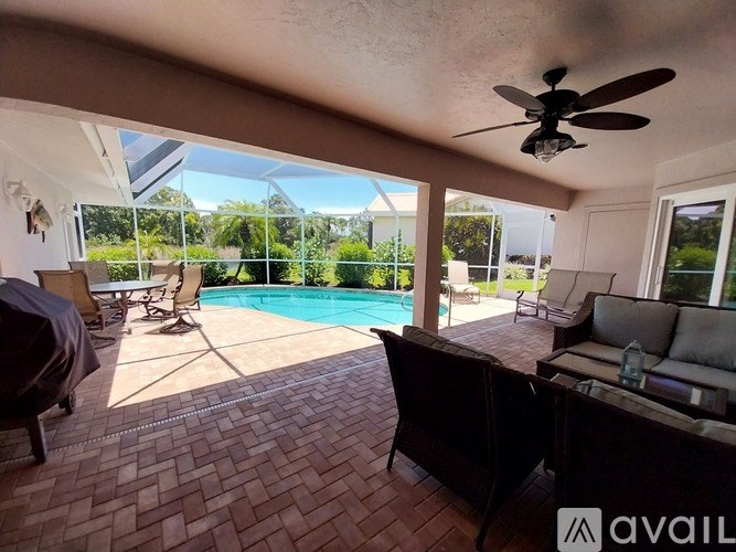 A patio with a pool and a ceiling fan.