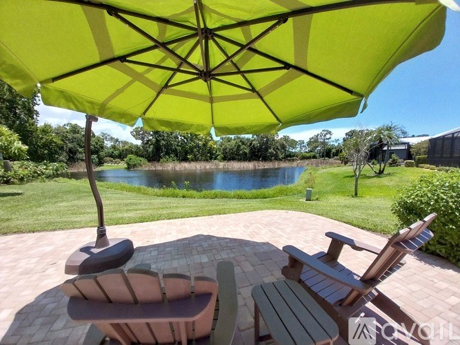 A yellow umbrella is open over a table and two chairs.