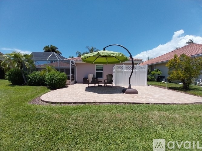 A patio with a table and chairs under an umbrella.