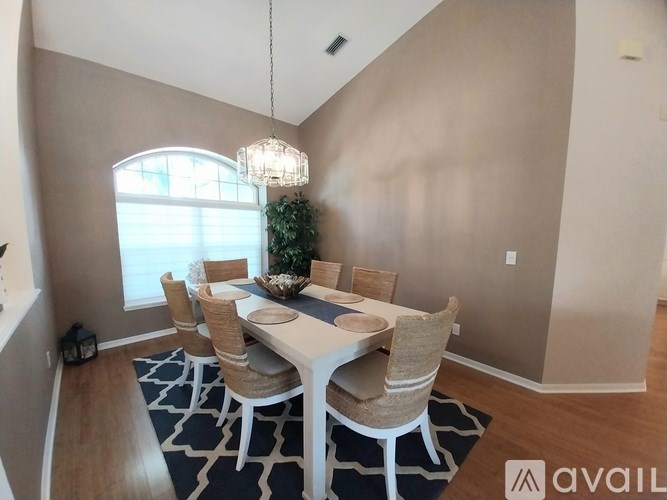 A dining room with a white table and chairs.