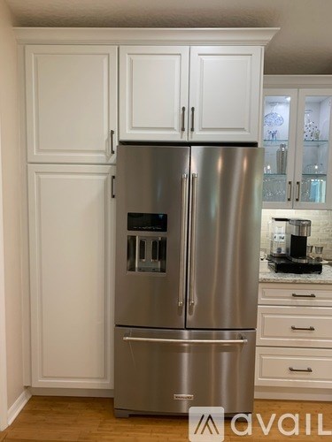 A stainless steel refrigerator with a freezer drawer and a water dispenser.
