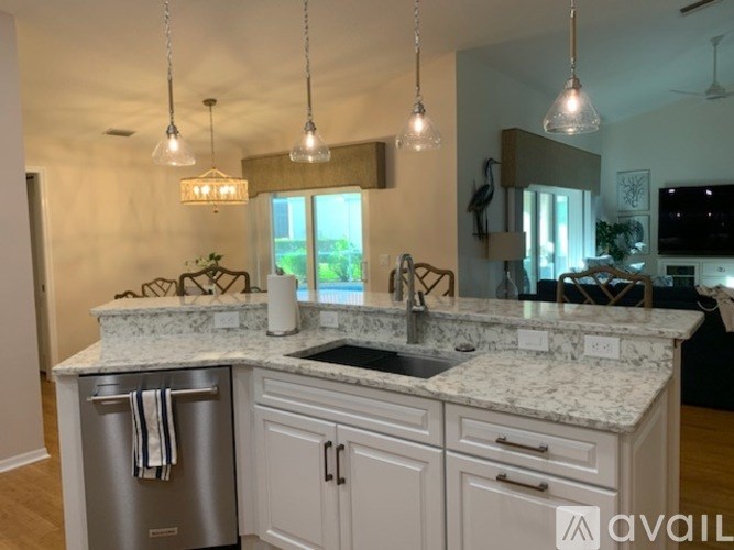 A kitchen with a marble countertop and a stainless steel dishwasher.