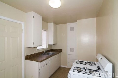 A small kitchen with a white stove top oven.