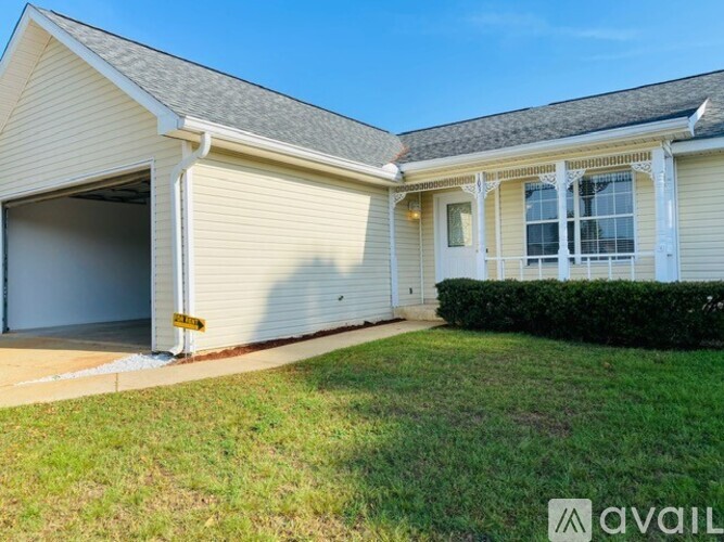 A house with a garage and a lawn in front.