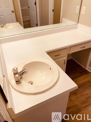 A bathroom sink with a white counter top and a mirror above it.