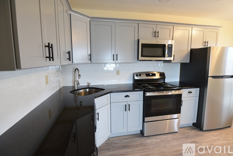 A kitchen with black and white cabinets and appliances.