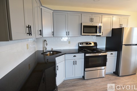 A kitchen with black and white cabinets and appliances.