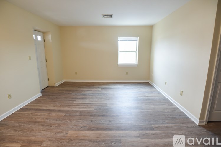 A room with wooden flooring and a window.