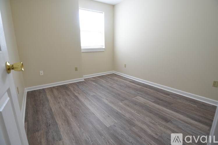 A room with wooden flooring and a window.