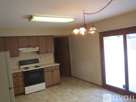A kitchen with a white oven and cabinets.