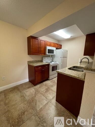 A kitchen with brown cabinets and a granite countertop.