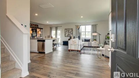 A spacious living room with a staircase on the left side.