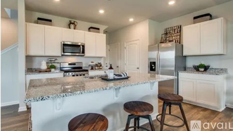 A kitchen with white cabinets and a granite countertop.