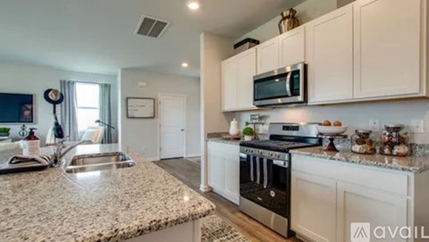 A kitchen with granite countertops and white cabinets.
