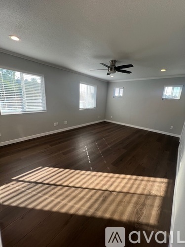 A room with wooden floors and a ceiling fan.