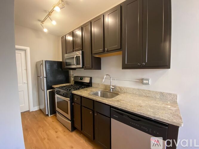 A kitchen with brown cabinets and a granite countertop.