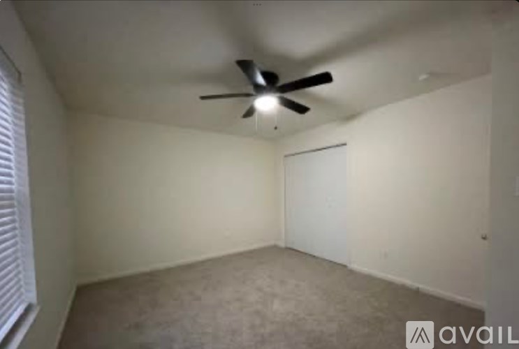 A room with a ceiling fan and a closed door.