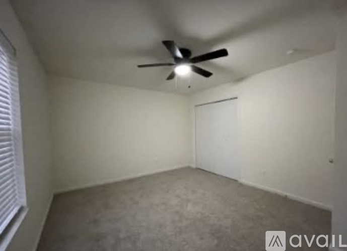 A room with a ceiling fan and a closed door.