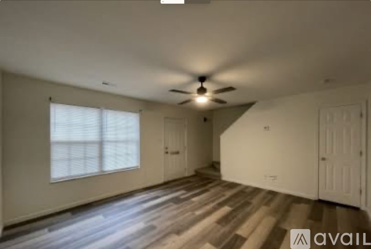 A room with a ceiling fan and wooden flooring.