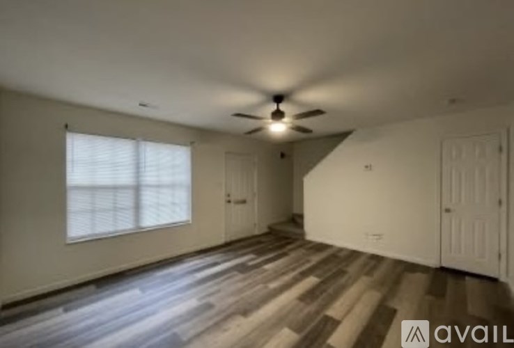A room with wooden flooring and a ceiling fan.