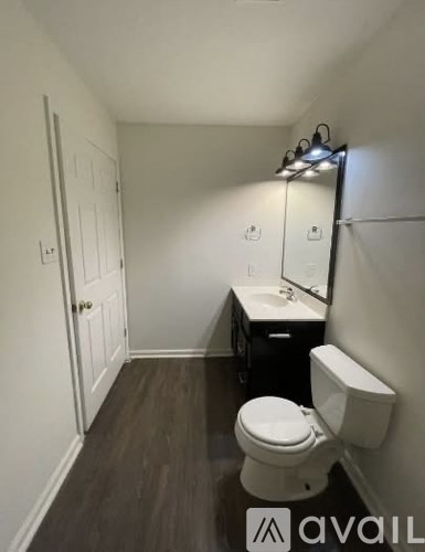 A small bathroom with a toilet, sink, and mirror.