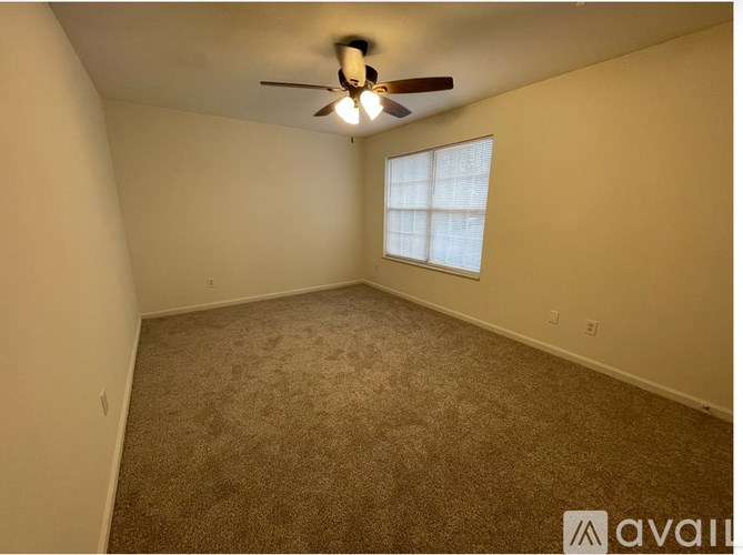 A room with a ceiling fan and a window.