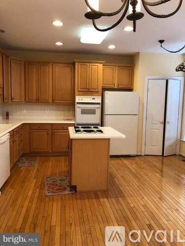 A kitchen with wooden cabinets and a white fridge.