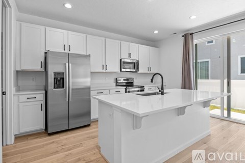 A modern kitchen with white cabinets and stainless steel appliances.