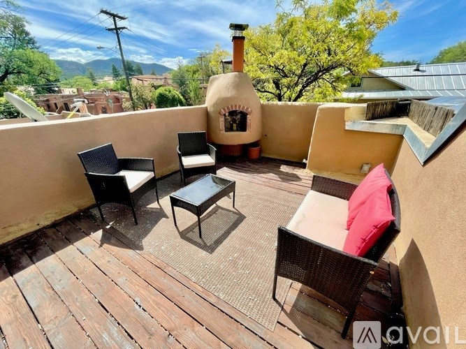 A patio with a table, chairs and a fireplace.