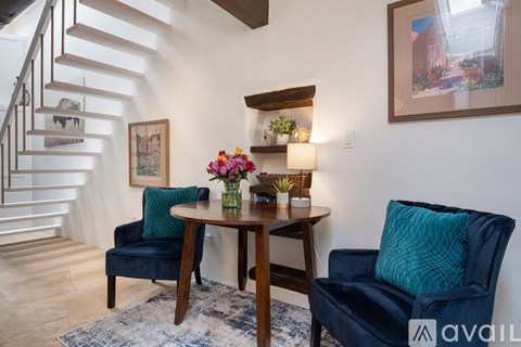 A living room with a blue chair and a wooden table.