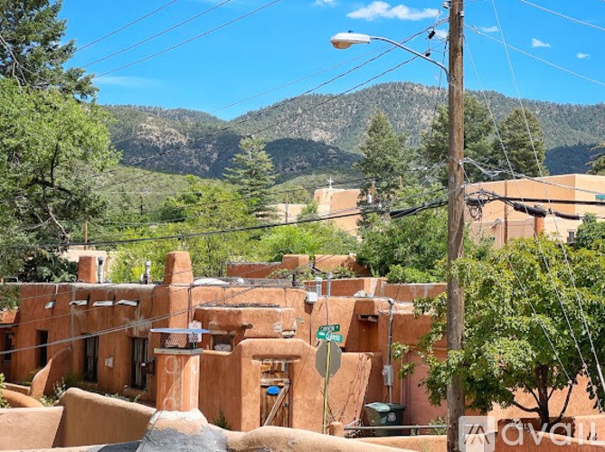 A small town with adobe buildings and mountains in the background.