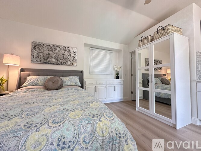 A bedroom with a bed, a nightstand, and a cabinet with glass doors.