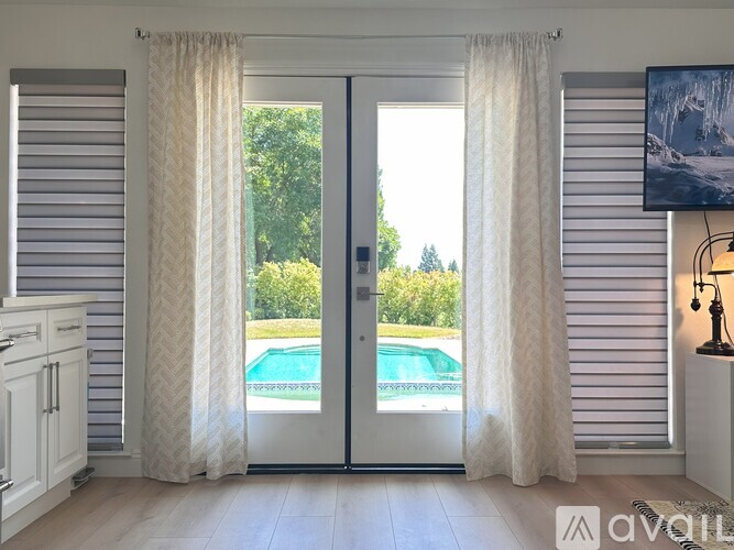 A room with a pool outside the sliding glass door.