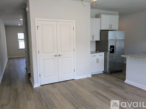A kitchen with white cabinets and a refrigerator.